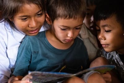 Two smiling children in a rural Cambodian community